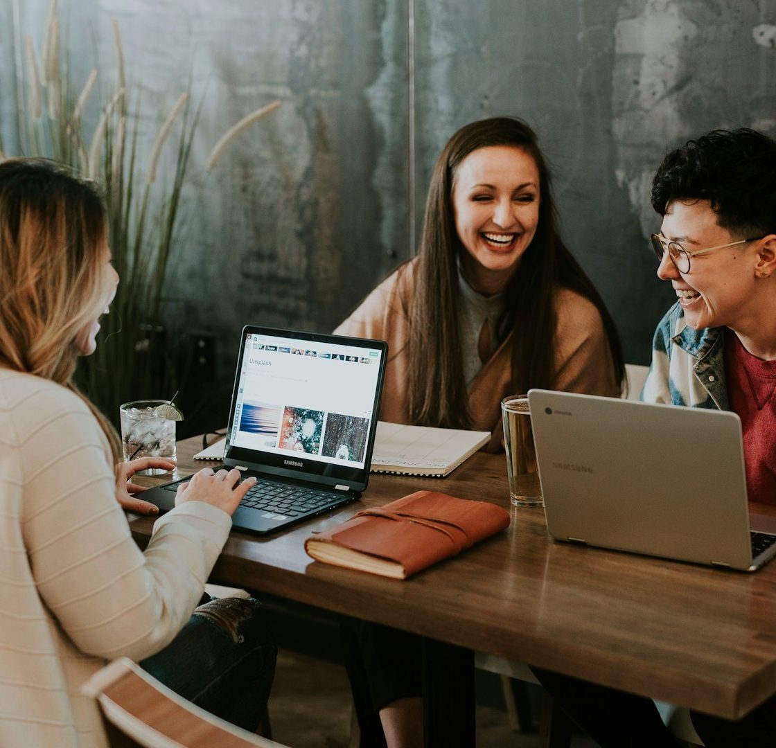 Drei Personen arbeiten kooperativ zusammen an Laptops