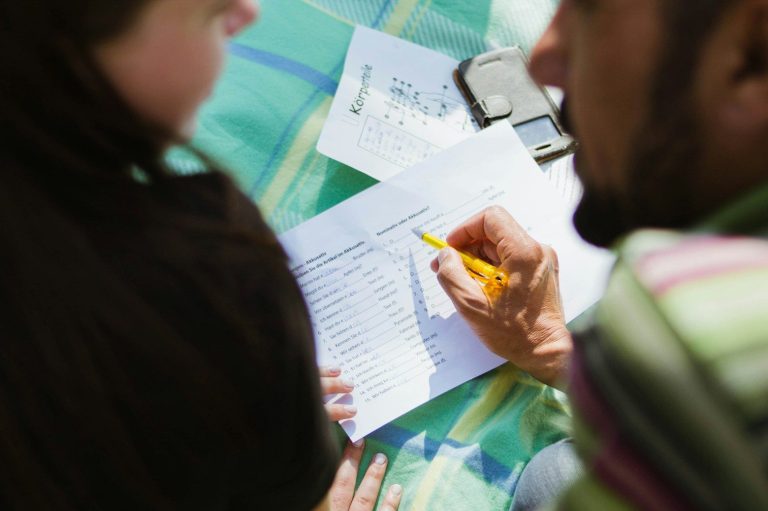 Personen arbeiten gemeinsam an möglichen Lösungen und machen sich dabei Notizen