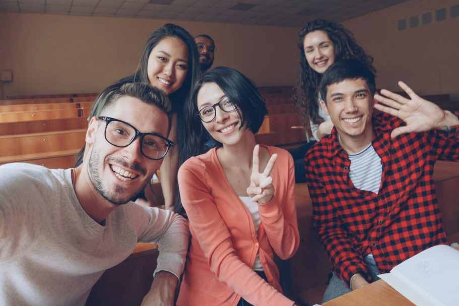 Lehrer im Unterricht in einer Klasse mit digitalen Medien im Hintergrund