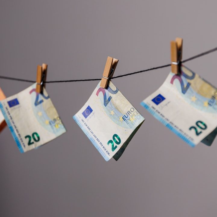 Frau arbeiten digital an einem Laptop und schreibt sich nebenher Notizen in einem Notizbuch auf